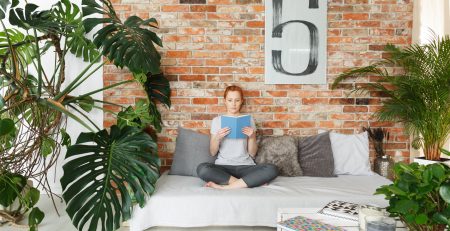 Young woman reading book in stylish contemporary apartment