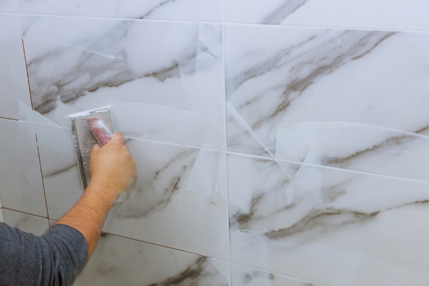 silver white marble tiles being grouted