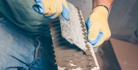 Workman using tiling adhesive