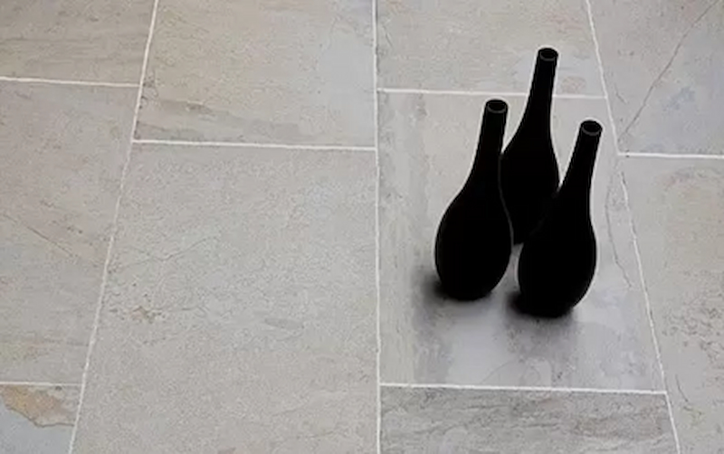 Black vases on a grey stone tiled floor 