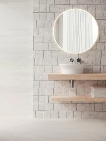 Pale coloured walls, mirror and sink with a tile skirting