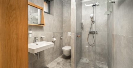 A bathroom with a glass shower and sink